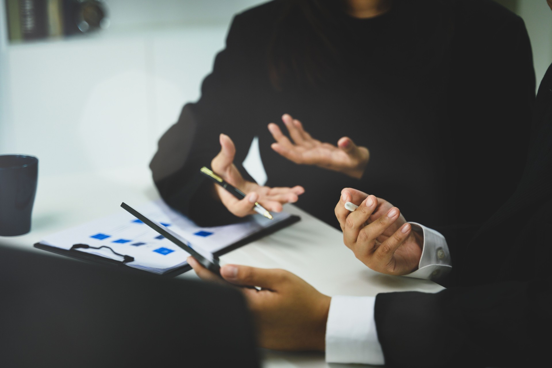 Business professionals discussing ideas with documents and digital tablet during meeting
